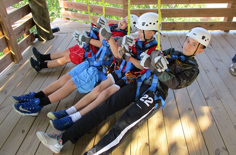 A young group of boys prepare to go on their zipline adventure